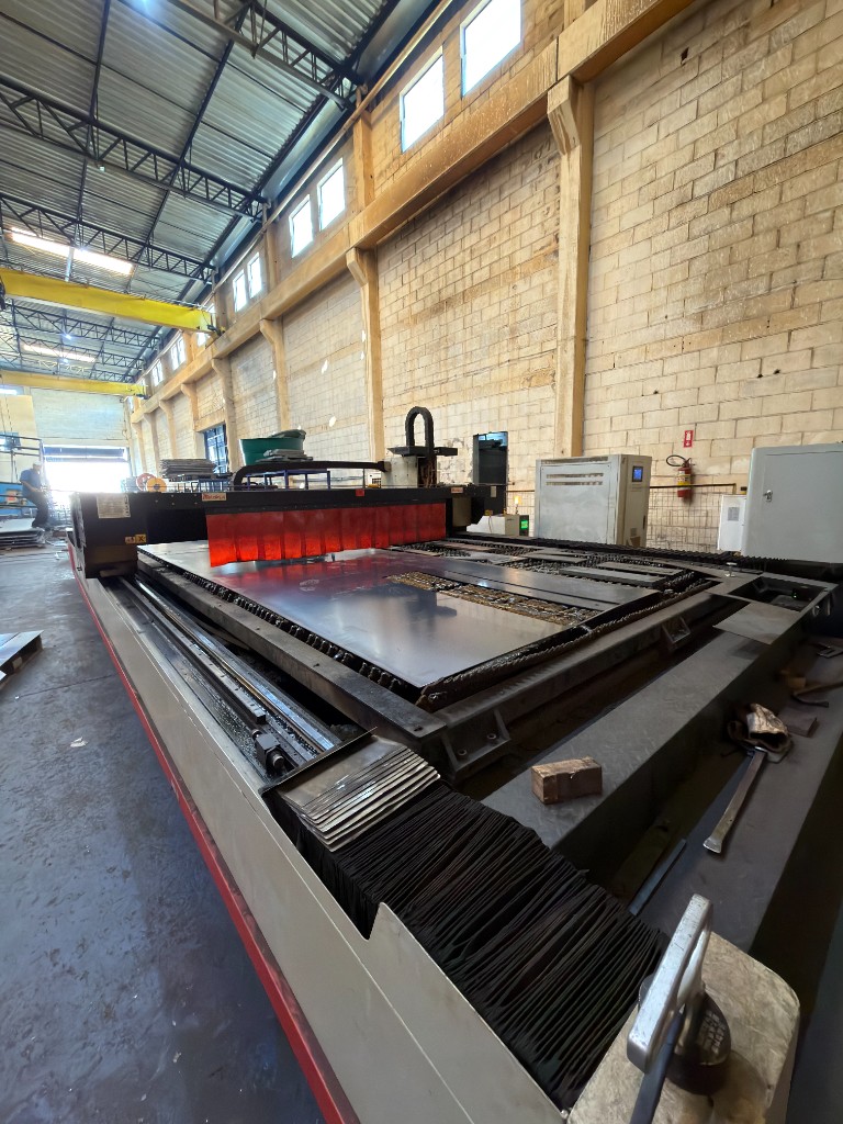 Corte a laser — mesa 6000×2500, 12 kW, corte até 38 mm aço carbono Máquina de corte a laser com mesa 6000×2500 mm, potência de 12 kW e corte até 38 mm em aço carbono no galpão da SteelForte em Sorocaba