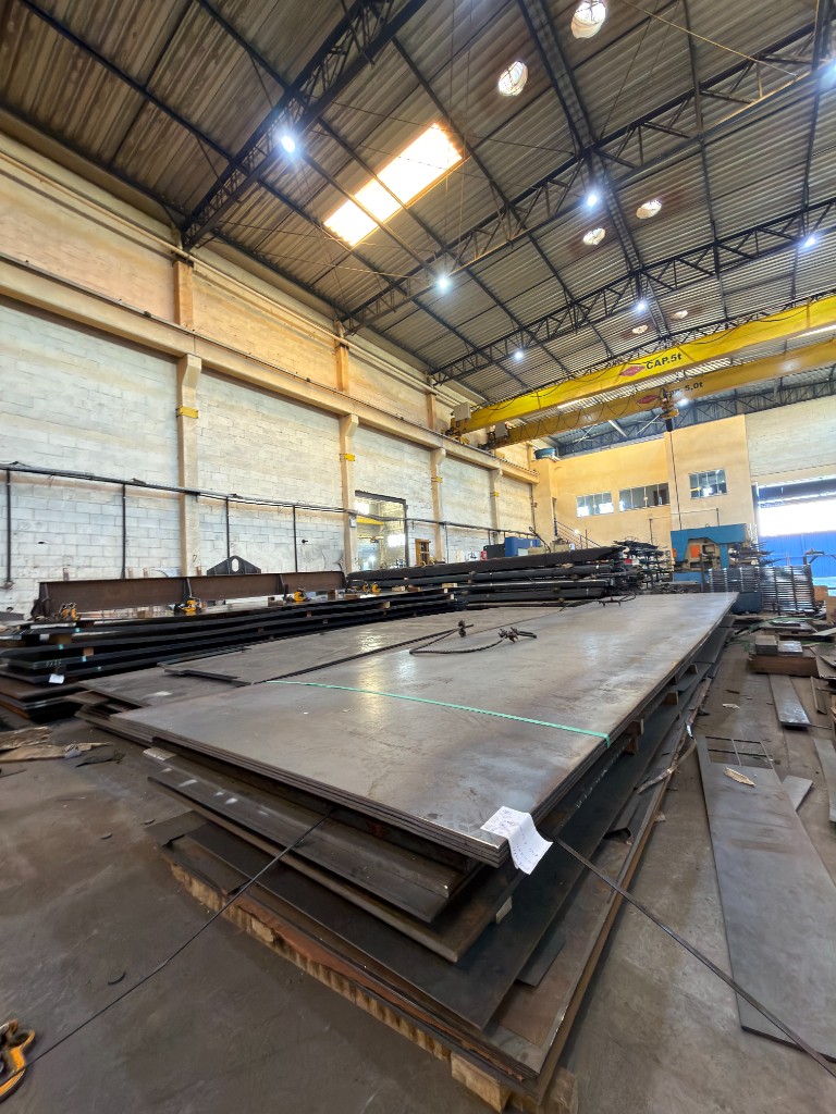 Estoque de chapas Estoque de chapas de aço empilhadas no galpão industrial da SteelForte com ponte rolante de 5 toneladas